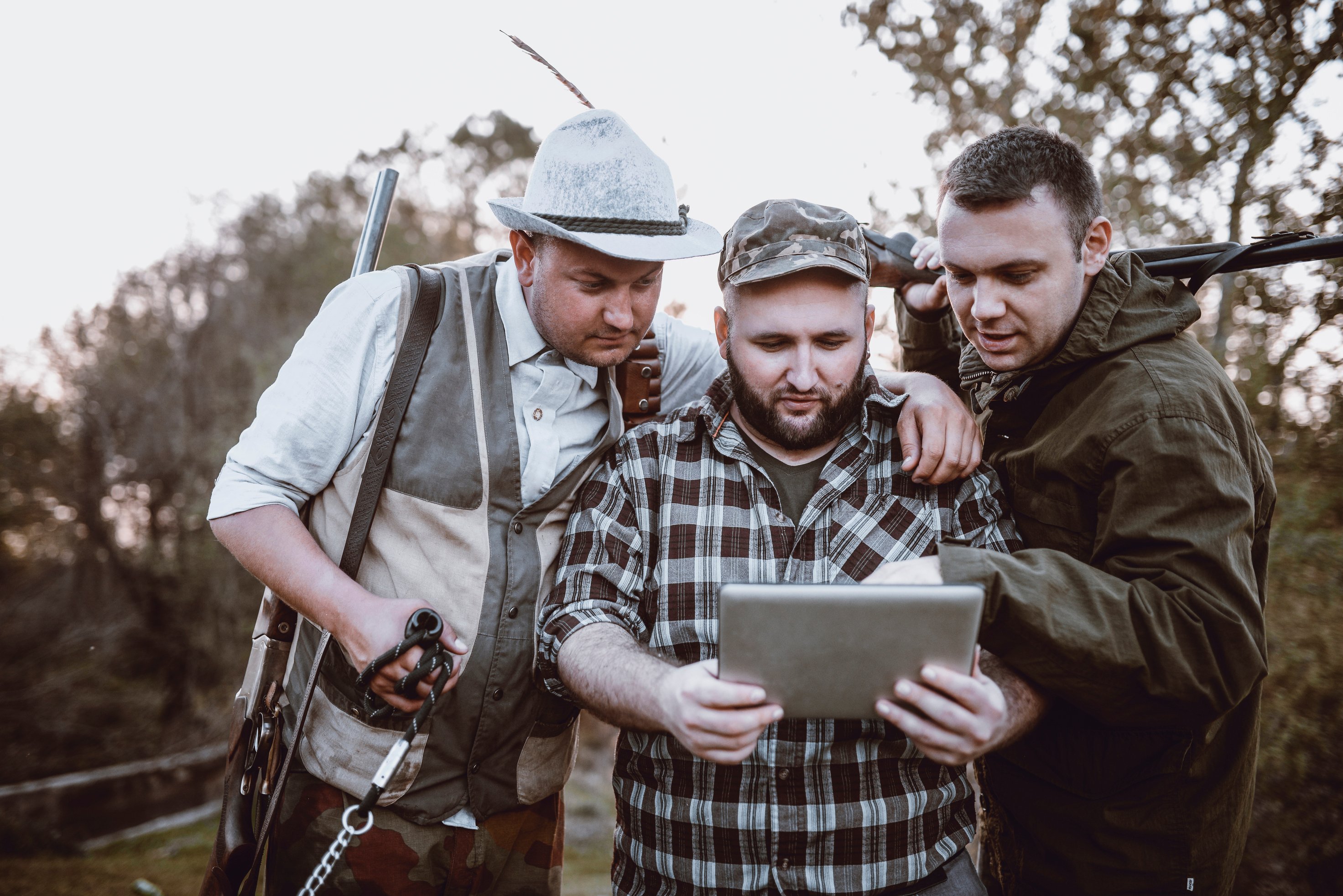 Modern Hunters Looking In Map On Tablet